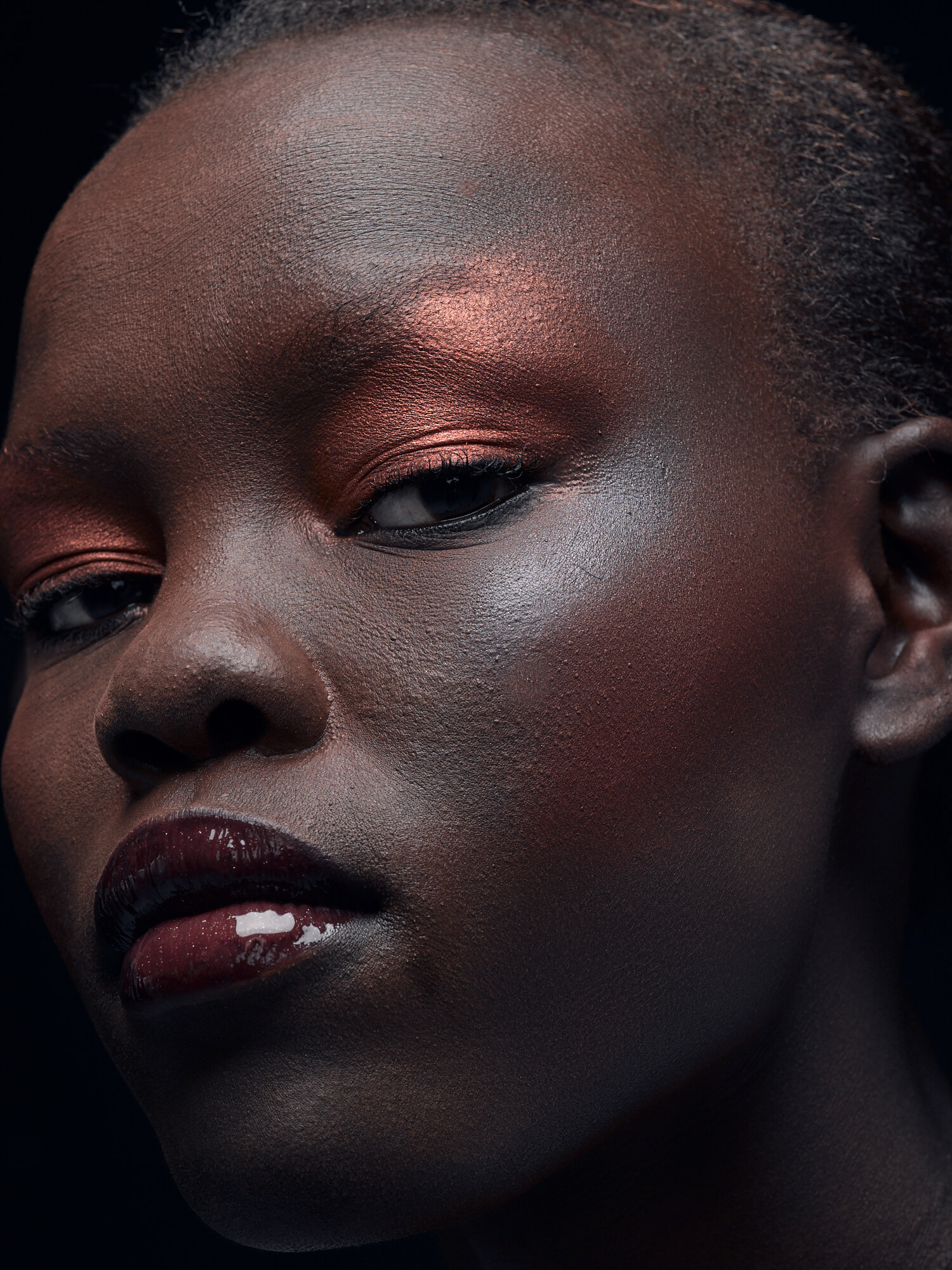 Grace Bol editorial beauty close-up, copper shimmer eyeshadow and a dark glossy lip on shadow. Beauty photography by Jason Guffy.