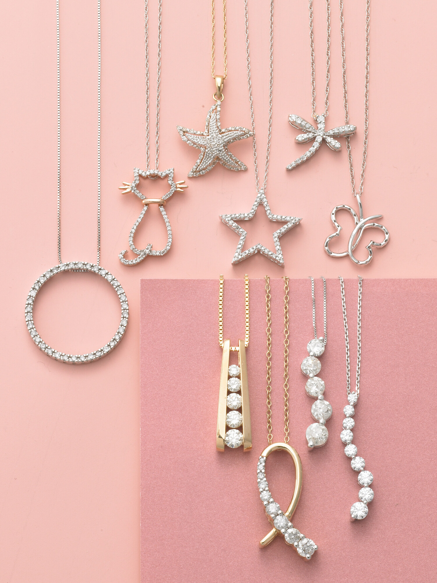 Delicate diamond pendant necklaces in cat, starfish, star, butterfly, and ribbon shapes on pink and coral background, Macy's jewelry catalog. Product photography by Jason Guffy.