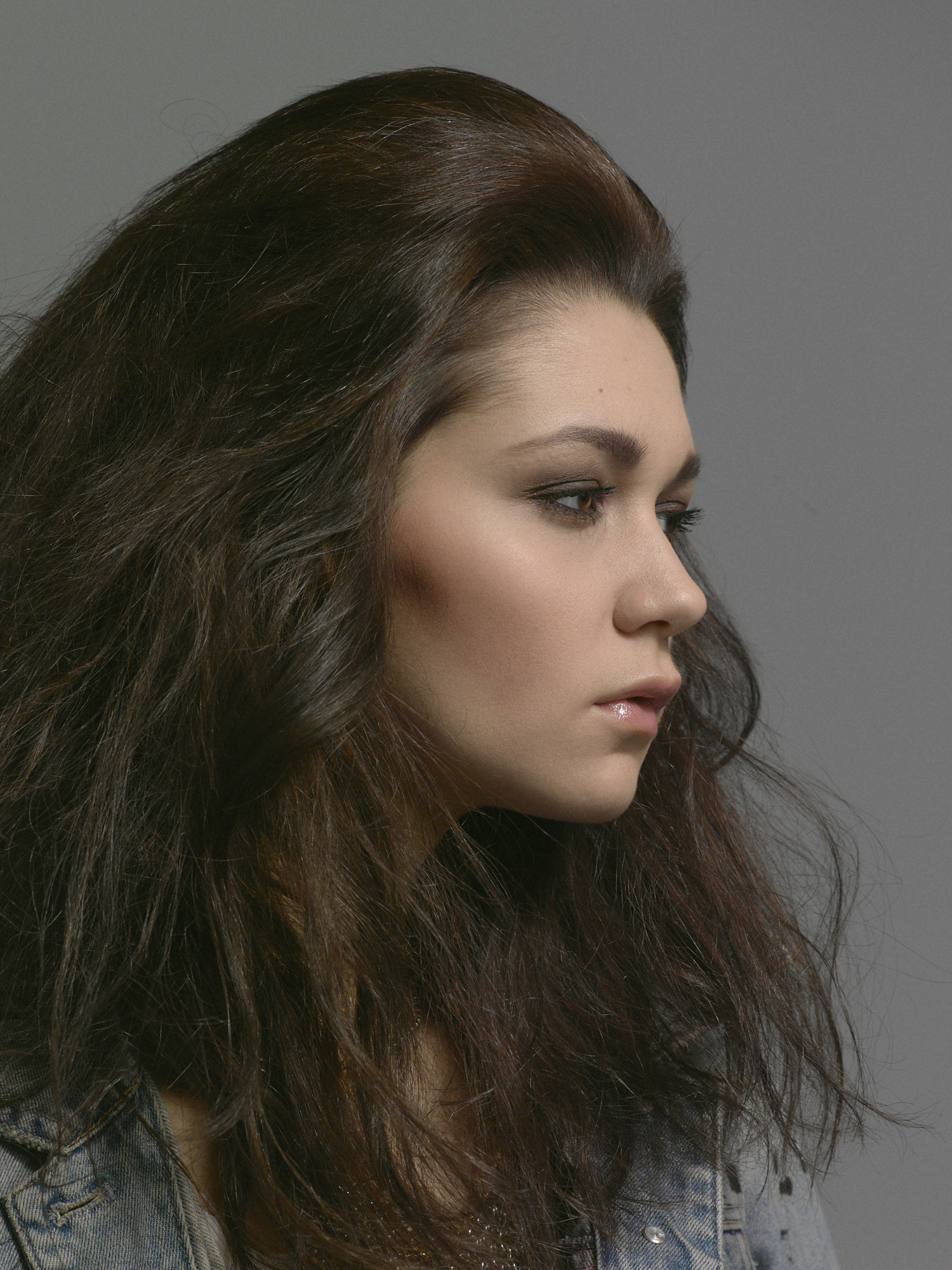 Studio beauty profile, a close portrait with sculpted volume on grey seamless. Hair by DJ Quintero. Jason Guffy Photography.